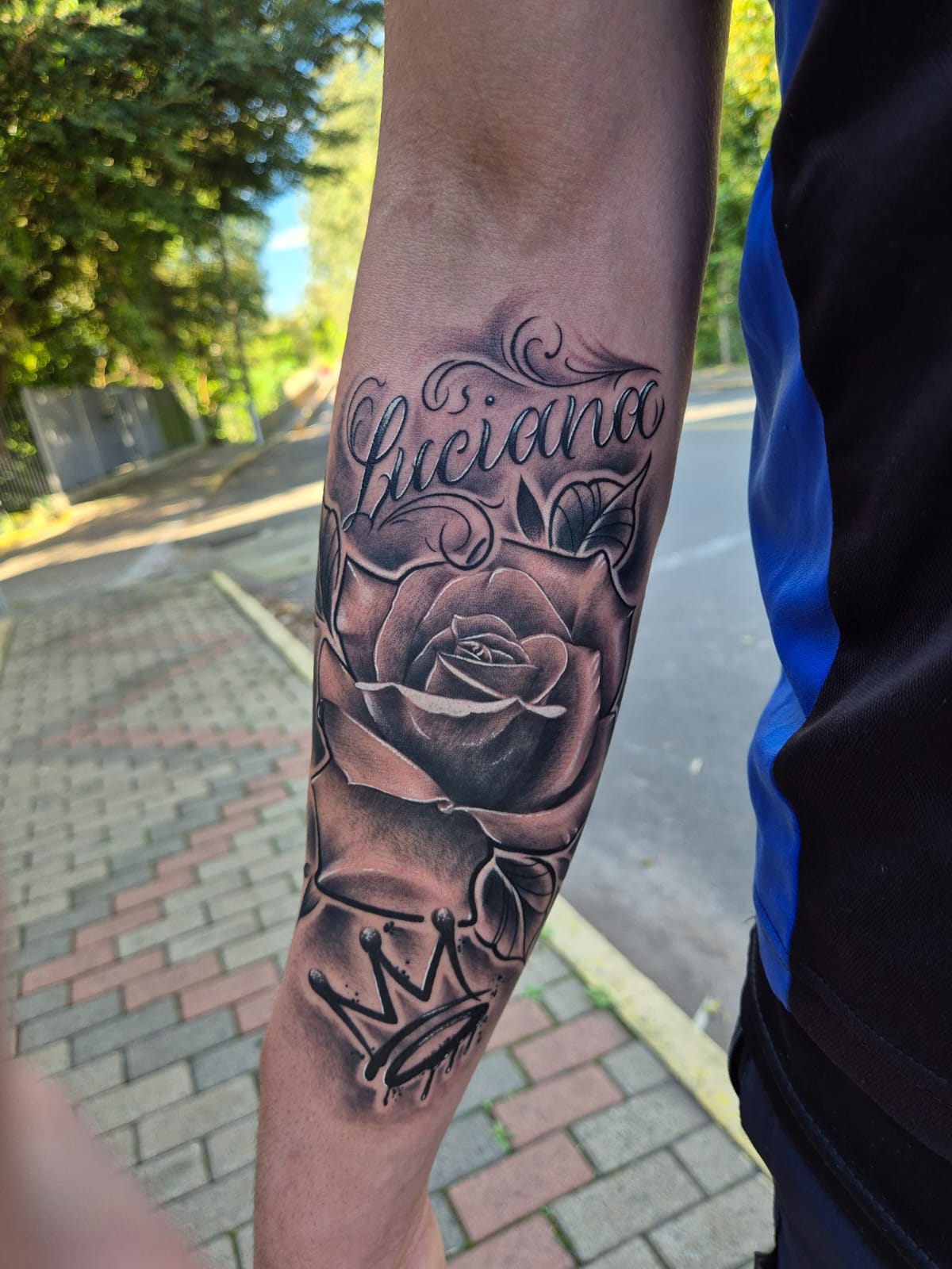 Tatuagem autoral de rosa com nome Luciana